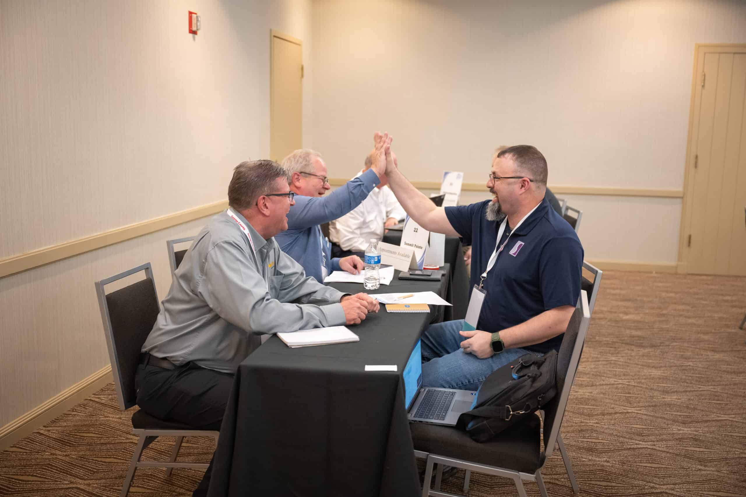 Impactful Connections at the 2024 IMPACT Connection - High Fives given between two members conducting business.